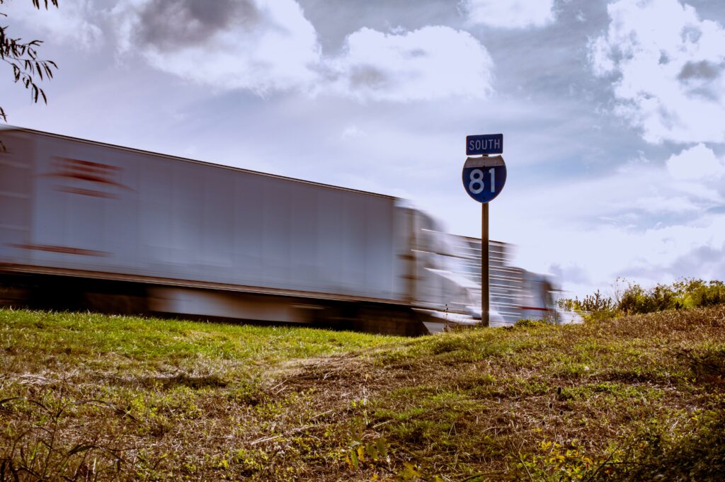 truck moving quickly past a highway sign